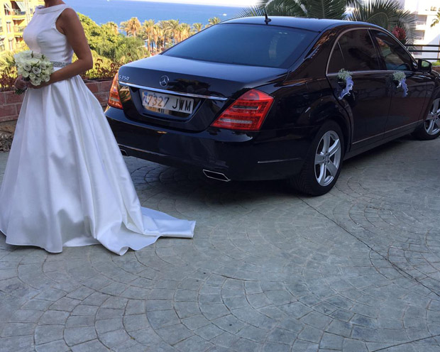 Imagen de coche de bodas con la novia vestida de blanco al lado