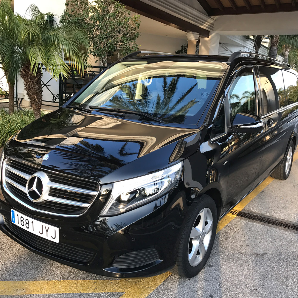 Imagen de una furgoneta negra aparcada en el porche de un edificio