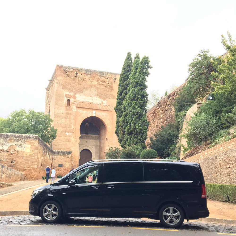 Imagen de una furgoneta negra delante de un edificio histórico
