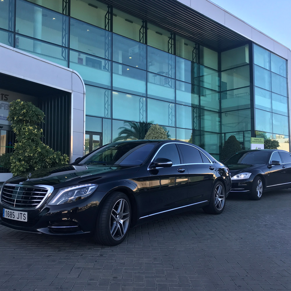 Imagen de varios coches elegantes estacionados delante de un edificio